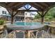 A beautiful pool and bar area featuring seating for four underneath a lovely wooden pergola at 332 Chaffin Rd, Roswell, GA 30075