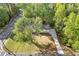 Aerial view of the house showcasing its mature trees, the driveway, and the surrounding landscape at 4718 Lou Ivy Rd, Peachtree Corners, GA 30096