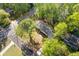 An aerial view of a property showcasing the yard, deck, surrounding streets, and lush green trees at 4718 Lou Ivy Rd, Peachtree Corners, GA 30096