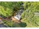 Aerial shot showing the house in a neighborhood and surrounding trees at 4718 Lou Ivy Rd, Peachtree Corners, GA 30096