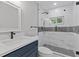 Modern bathroom featuring a glass shower with a rain shower head and a navy blue vanity at 4718 Lou Ivy Rd, Peachtree Corners, GA 30096