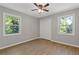 Bright bedroom with two windows and a closet offering scenic outdoor views at 4718 Lou Ivy Rd, Peachtree Corners, GA 30096