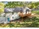 Exterior shot of the house with a deck, concrete driveway, well-kept lawn, and lush landscaping at 4718 Lou Ivy Rd, Peachtree Corners, GA 30096