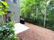 Serene backyard with a grill, concrete patio and a black metal fence surrounded by lush greenery at 11212 Snowy Owl Ln, Alpharetta, GA 30022