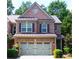 Charming two-story brick home featuring a well-manicured lawn and an attached two-car garage at 11212 Snowy Owl Ln, Alpharetta, GA 30022
