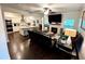 Inviting living room showcases an open layout, modern kitchen, fireplace, and hardwood floors at 11212 Snowy Owl Ln, Alpharetta, GA 30022