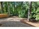 Large backyard space with fresh landscaping, bordered by mature trees and a wooden fence, offering privacy and natural beauty at 2438 Shadburn Ferry Dr, Buford, GA 30518