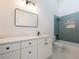 Modern bathroom features a white vanity, black hardware, and glass-enclosed shower with elegant blue tile at 2438 Shadburn Ferry Dr, Buford, GA 30518