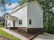 Side angle of a charming two-story white home with well-maintained landscaping and mature trees at 2438 Shadburn Ferry Dr, Buford, GA 30518