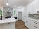 Bright kitchen featuring white cabinets, stainless steel appliances, and stylish grey brick backsplash at 2438 Shadburn Ferry Dr, Buford, GA 30518