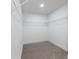 Spacious walk-in closet featuring wire shelving, carpeted flooring, and freshly painted white walls at 2438 Shadburn Ferry Dr, Buford, GA 30518
