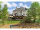 Exterior rear view of the home with expansive deck and landscaped backyard at 3605 Grey Abbey Dr, Alpharetta, GA 30022