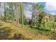 Lush backyard with mature trees, shrubs, and views of the home's exterior at 3605 Grey Abbey Dr, Alpharetta, GA 30022