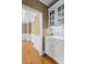 Butler pantry features white cabinetry, hardwood floors and decorative molding at 3605 Grey Abbey Dr, Alpharetta, GA 30022