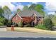 Two-story brick home featuring manicured landscaping, gray roof, black shutters, and a central front door at 3605 Grey Abbey Dr, Alpharetta, GA 30022