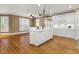 Open-concept kitchen with an island, white cabinets, hardwood floors, and stainless appliances at 3605 Grey Abbey Dr, Alpharetta, GA 30022