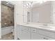 Bright bathroom featuring double sink vanity with white cabinets and stone countertop, plus a tiled shower and tub at 4236 Silver Spruce Ln, Smyrna, GA 30080