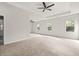 Spacious bedroom with carpet floors, recessed lighting, a ceiling fan, and large windows overlooking a leafy yard at 4236 Silver Spruce Ln, Smyrna, GA 30080