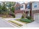 A charming two-story brick townhome featuring an attached garage and manicured landscaping at 4236 Silver Spruce Ln, Smyrna, GA 30080