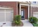 View of front entrance and garage of a brick townhome with manicured landscaping at 4236 Silver Spruce Ln, Smyrna, GA 30080