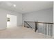 Bright upstairs hallway featuring carpet floors, access to bedrooms, and a staircase with ornate wrought iron spindles at 4236 Silver Spruce Ln, Smyrna, GA 30080