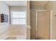 Bright bathroom featuring a relaxing garden tub with window view and a convenient, enclosed shower at 1193 Colony Creek Ct, Lawrenceville, GA 30043