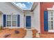 Close-up of a home's inviting blue front door framed by brick, white siding, and neatly landscaped flower beds at 1193 Colony Creek Ct, Lawrenceville, GA 30043