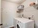 Bright laundry room featuring a modern washer and dryer, storage shelves, and decorative wall art at 1193 Colony Creek Ct, Lawrenceville, GA 30043