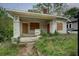 Charming bungalow-style home with a covered porch and overgrown yard needs renovation and TLC at 1366 Sylvan Sw Rd, Atlanta, GA 30310