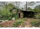Overgrown exterior of a dilapidated building with a collapsing roof at 1366 Sylvan Sw Rd, Atlanta, GA 30310