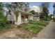 Distressed bungalow-style home with overgrown front yard, boarded windows, and covered front porch at 1366 Sylvan Sw Rd, Atlanta, GA 30310
