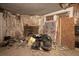 Damaged room interior featuring debris, brick fireplace and window; potential for renovation at 1366 Sylvan Sw Rd, Atlanta, GA 30310