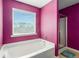 Bright bathroom featuring a soaking tub, walk-in shower, and a window at 3798 Broadleaf Walk, Snellville, GA 30039