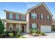 Charming two-story brick home with manicured landscaping and a welcoming front porch at 3798 Broadleaf Walk, Snellville, GA 30039