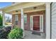 Charming brick home entrance with a covered front porch, pillars, and a well-kept garden at 3798 Broadleaf Walk, Snellville, GA 30039