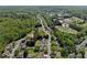 Wide aerial view of a residential neighborhood nestled among dense green trees on a sunny day at 3452 Hard Creek Ln, Buford, GA 30519