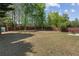 Expansive backyard with a patio set, surrounded by mature trees and a wooden fence at 3452 Hard Creek Ln, Buford, GA 30519