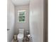 Half bathroom featuring tile floors, neutral paint, a window, and a toilet with a modern design at 3452 Hard Creek Ln, Buford, GA 30519