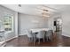 Elegant dining room with dark wood floors, modern light fixture, and a view to the backyard at 3452 Hard Creek Ln, Buford, GA 30519