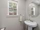 Well-lit powder room with modern fixtures and a pedestal sink at 3452 Hard Creek Ln, Buford, GA 30519