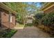 A gravel-covered backyard with mature trees and landscaping between two brick homes at 629 Pinetree Dr, Decatur, GA 30030
