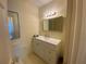 Half bath with white vanity, gold fixtures, and framed mirror at 629 Pinetree Dr, Decatur, GA 30030