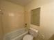 Full bath with white tile, tub, toilet, and framed mirror at 629 Pinetree Dr, Decatur, GA 30030