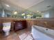 Spacious bathroom featuring a large soaking tub, ornate vanity, and a mirrored wall at 629 Pinetree Dr, Decatur, GA 30030