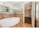 Bright bathroom with a pristine white tub, tile accents, and a large mirrored wall that expands the space at 629 Pinetree Dr, Decatur, GA 30030