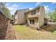 Backyard with grassy lawn, exterior home with tan siding, concrete patio and privacy wall at 114 Oakview Psge, Canton, GA 30114