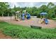 The playground has multiple slides and play structures surrounded by greenery and a bench for resting at 114 Oakview Psge, Canton, GA 30114