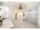 Bright bathroom features marble floors, soaking tub, glass shower, and a decorative chandelier at 3511 Roxboro Ne Rd, Atlanta, GA 30326