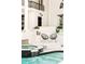 Outdoor patio features a pool, waterfall, modern seating, and column-lined architectural details at 3511 Roxboro Ne Rd, Atlanta, GA 30326