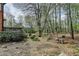 Scenic backyard with a water fountain, lush greenery, and access to a wooden deck at 220 Carriage Station Dr, Lawrenceville, GA 30046